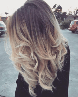 Brunette roots transitions to bright blonde hair