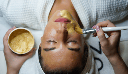 An esthetician applies a serum to her client's face, one of the key ways to ensure this customer comes back for more is to focus on client retention.