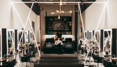 A cosmetologist washes her clients hair inside a high-end salon she found using the app ArtistonGo (AOG).