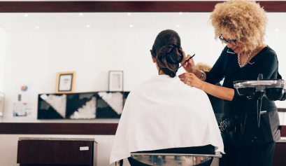 A stylist works on her client hair as part of her partnering with a cause program.