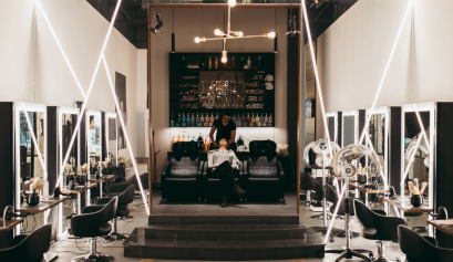 A stylist works on her client's hair in her full-service salon.