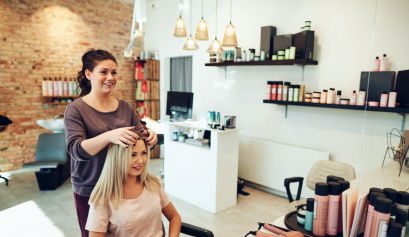 A hair stylist works on her clients hair on National Hairstylist Appreciation Day.