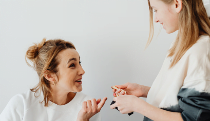 A cosmetologist works on her client's hair while she discusses mental health awareness month.