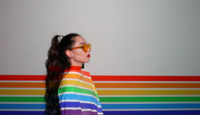 A cosmetologist wears a rainbow flag while she supports Pride 2023.
