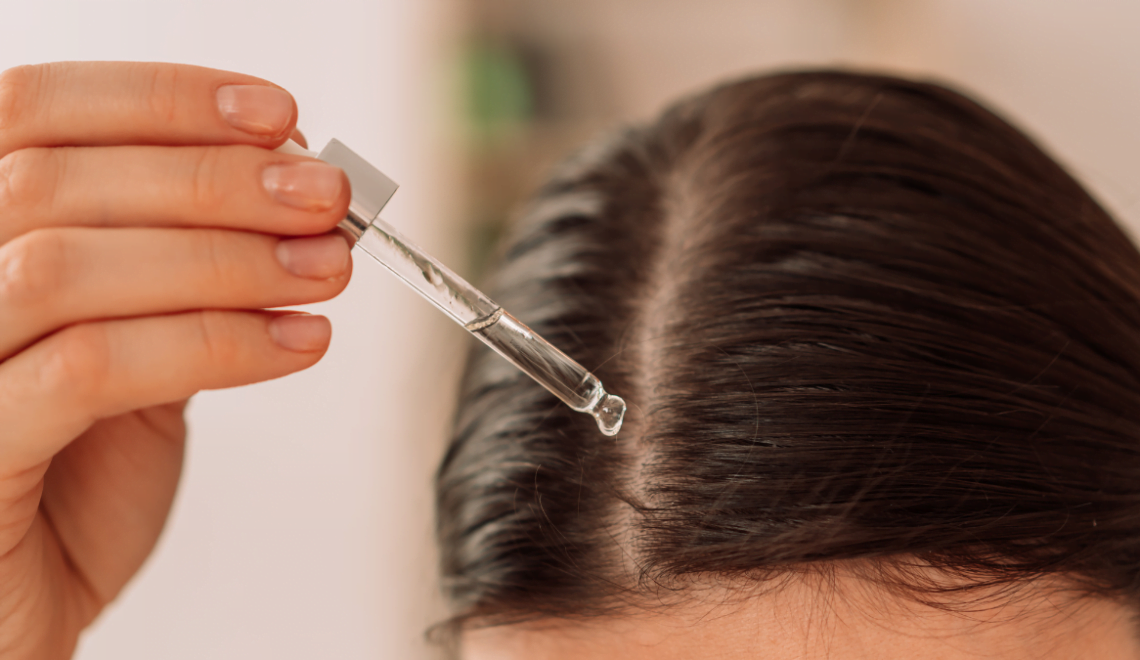 A client applies a tea tree oil serum to their roots to help with their dander.