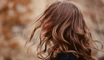 A client shows off her Fall beauty trend hair that her stylist completed for her.