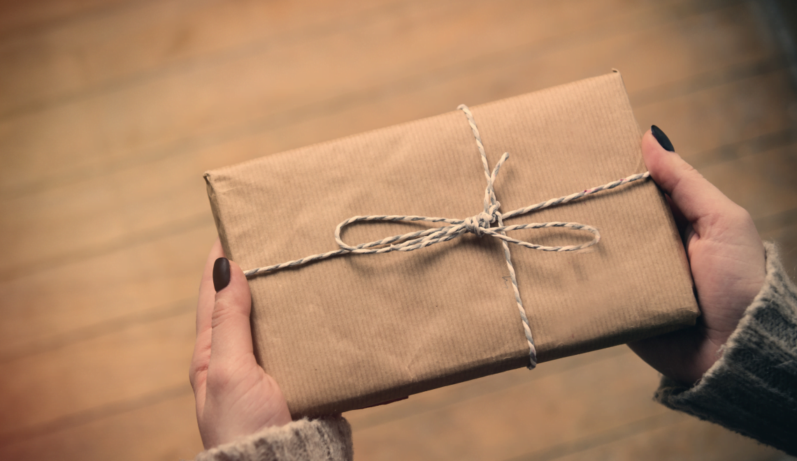 A cosmetologist shows off a neatly wrapped present she chose from the client gift guide.