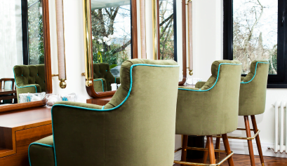 A beauty pro's at-home beauty business is designed with green chairs in her home space.