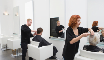 Two clients get their hair cut by two new beauty pros hired for the salon.
