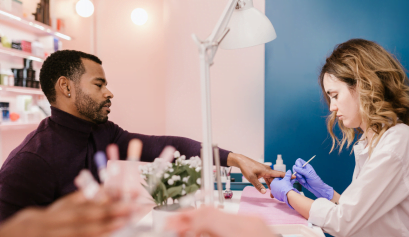 A client receives customer service from a nail tech at her salon.